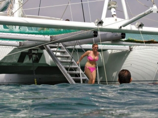  Frau geht eine Treppe hinunter, um im Meer zu baden 